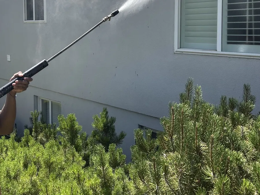Lucent Exteriors technician washing stucco siding