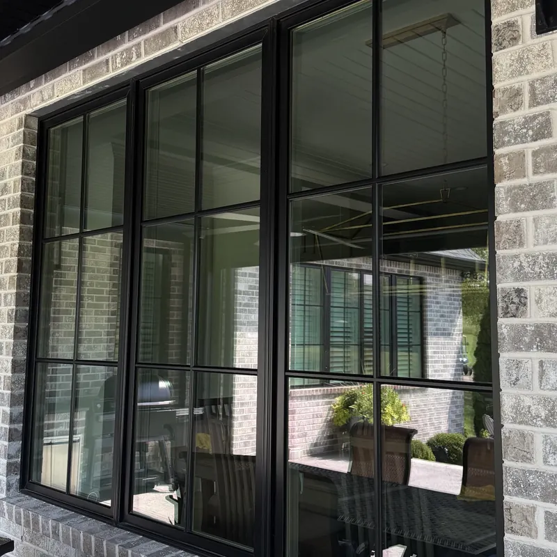 Clean black-framed windows set in gray brick