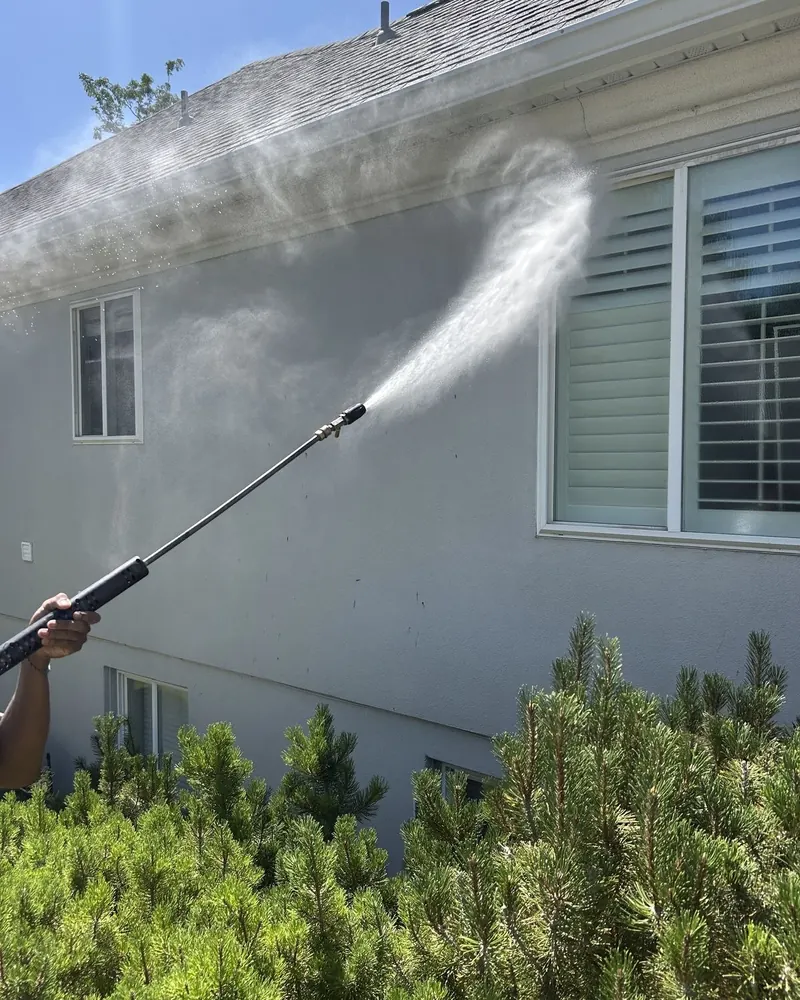 Lucent Exteriors technician washing stucco siding, Nashville house washing